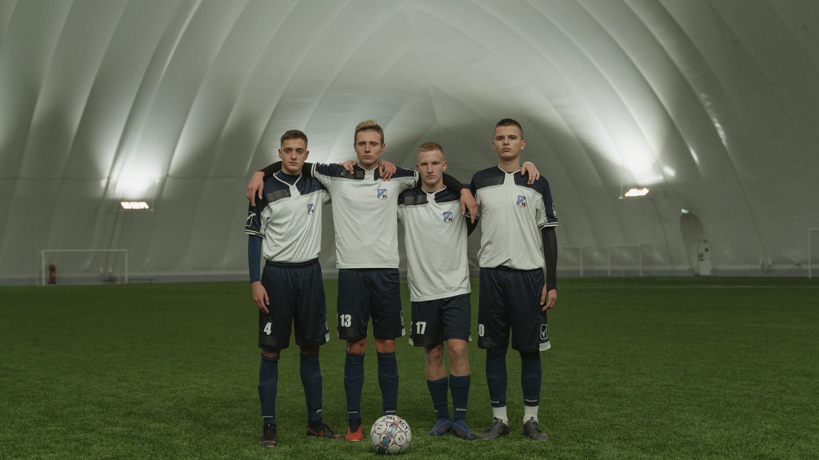 Jeunes joueurs reunis autour d un ballon sur un terrain couvert